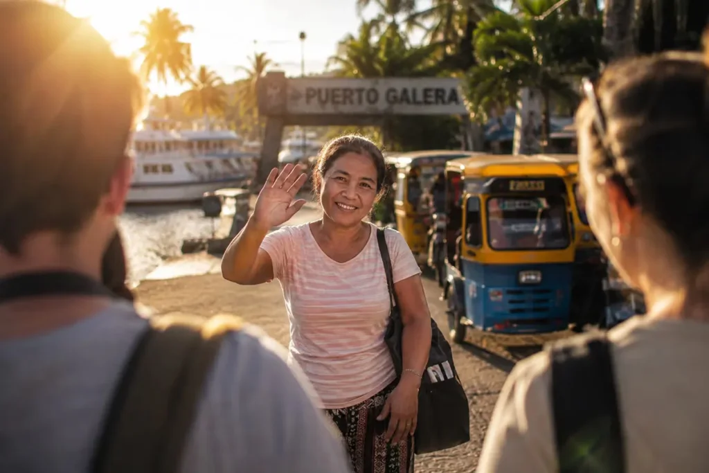Filipino woman warmly greeting tourists at Puerto Galera port, Mindoro Island, Philippines